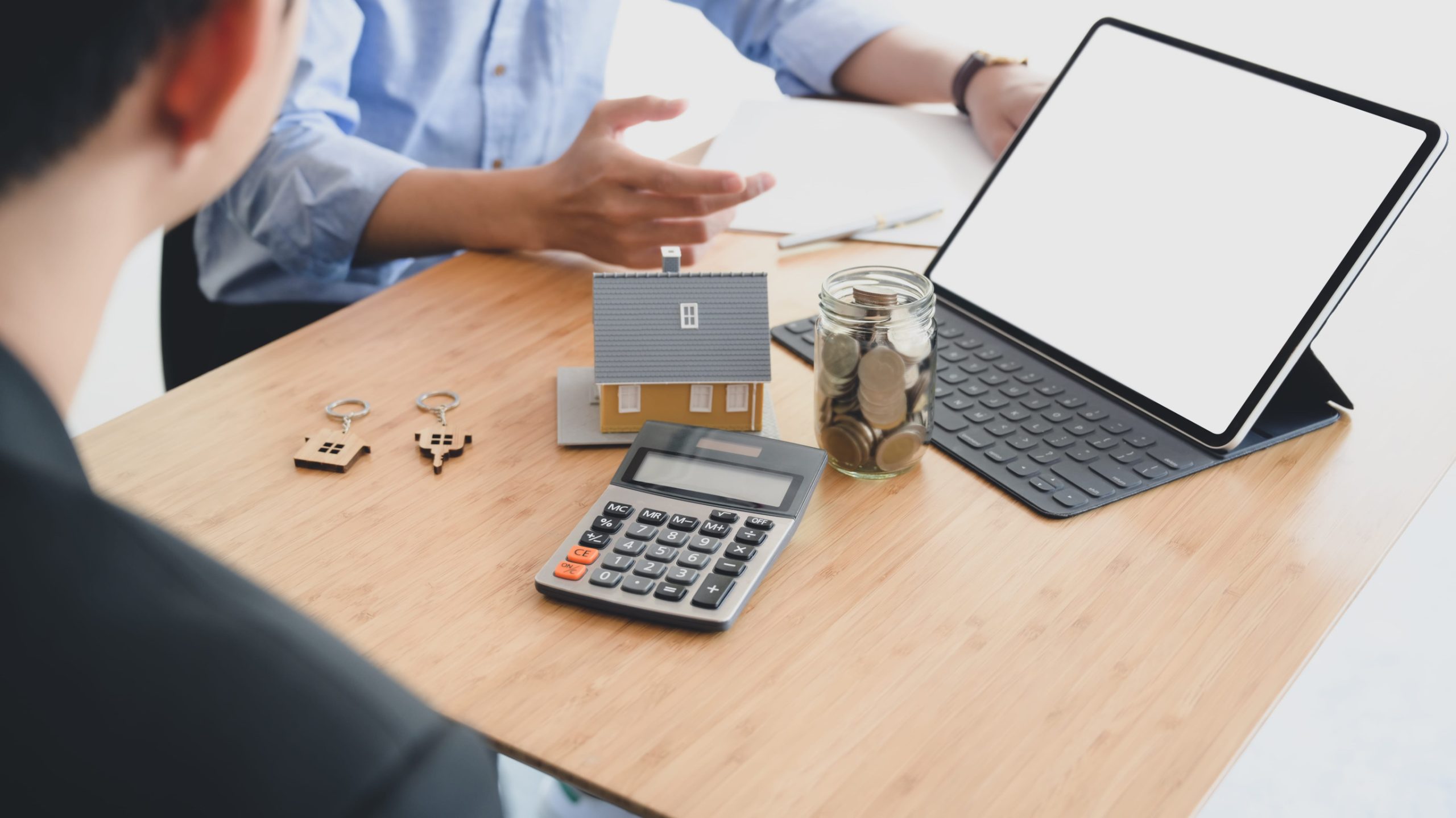 people calculating interest, taxes and profits to invest in real estate and home buying with mock up tablet and calculator
