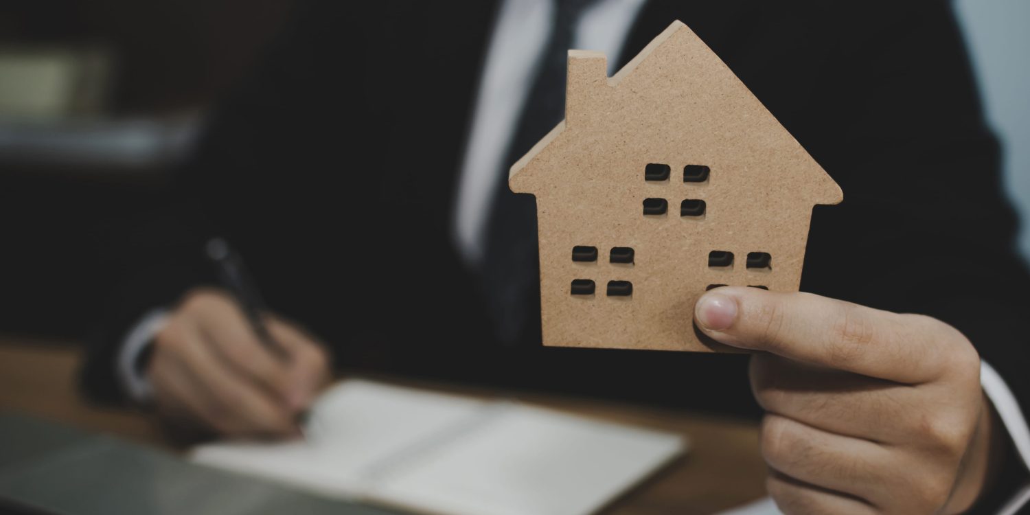 real estate broker manager in suit giving house model to customer after signing contract for buying house in estate agent office, real estate, finance, home loan contract, buy and sell house concept